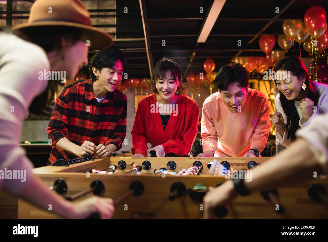 Happy young Chinese friends playing table football Stock Photo