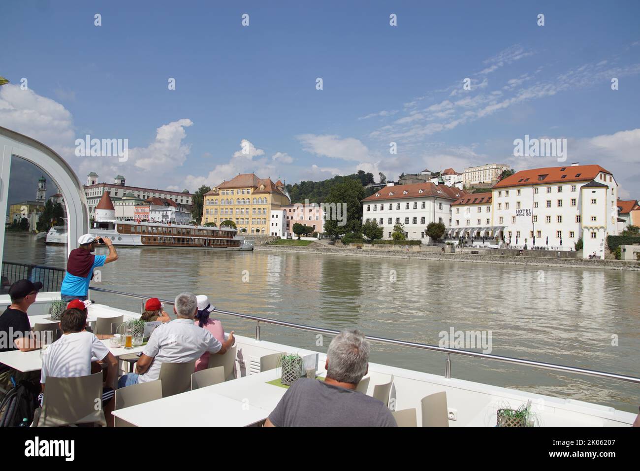 White deck with people on a sightseeing boat looking at the German city of Passau, sailing on the Inn river. Summer, August, Germany. Stock Photo