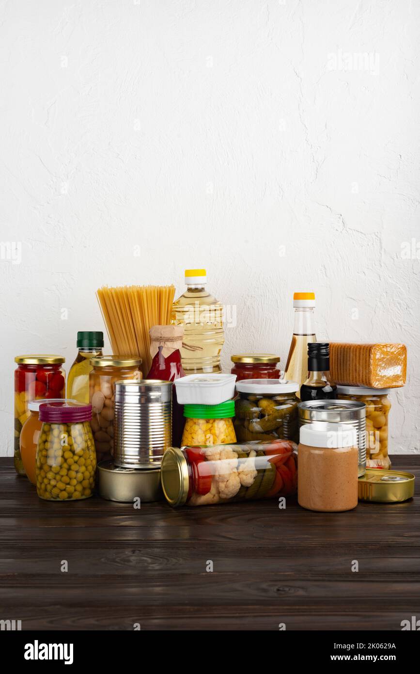 Emergency survival food set on dark wooden kitchen table Stock Photo