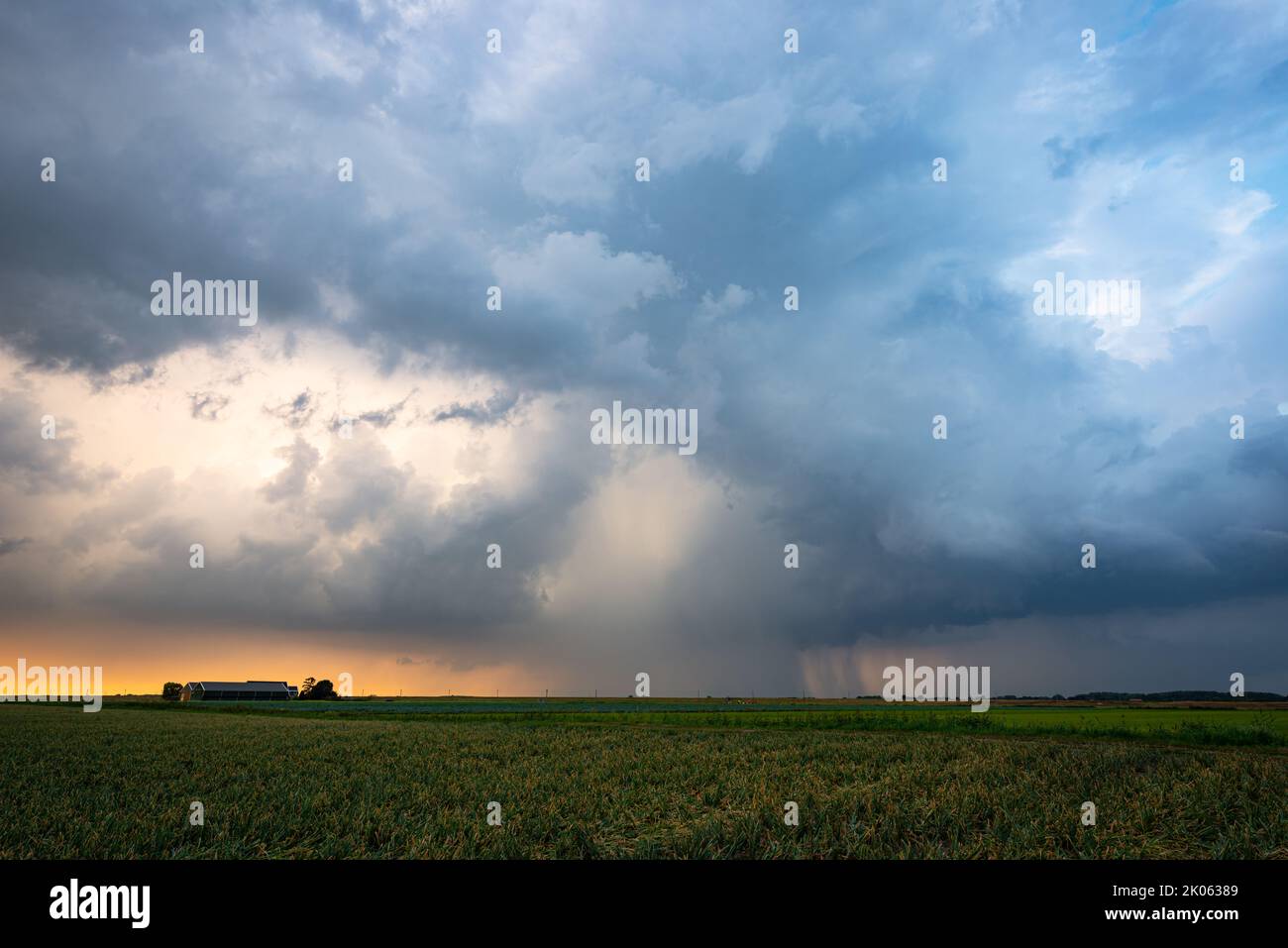 Ominous spectacle as threatening clouds of a thunderstorm pass in the evening light Stock Photo
