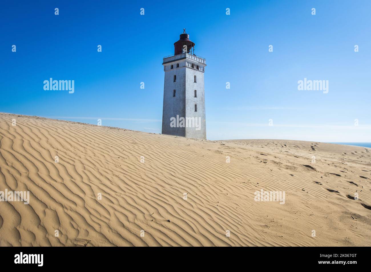 The iconic lighthouse Rubjerg Knude Fyr in the dunes of northern Denmark on a summer day Stock Photo