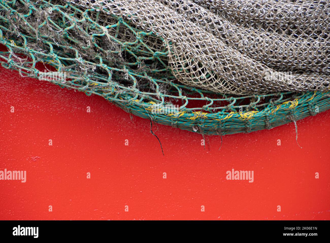 Fishing net hanging over red background Stock Photo