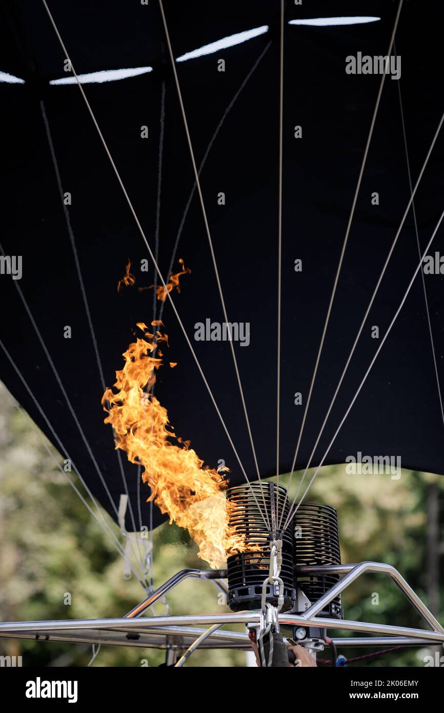 A man uses a double gas burner to inflate a hot air balloon Stock Photo