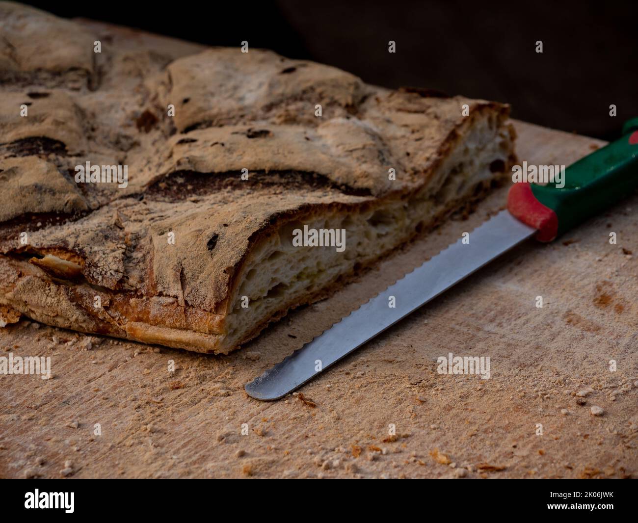 close-up shot knife with cut bread on a table Stock Photo
