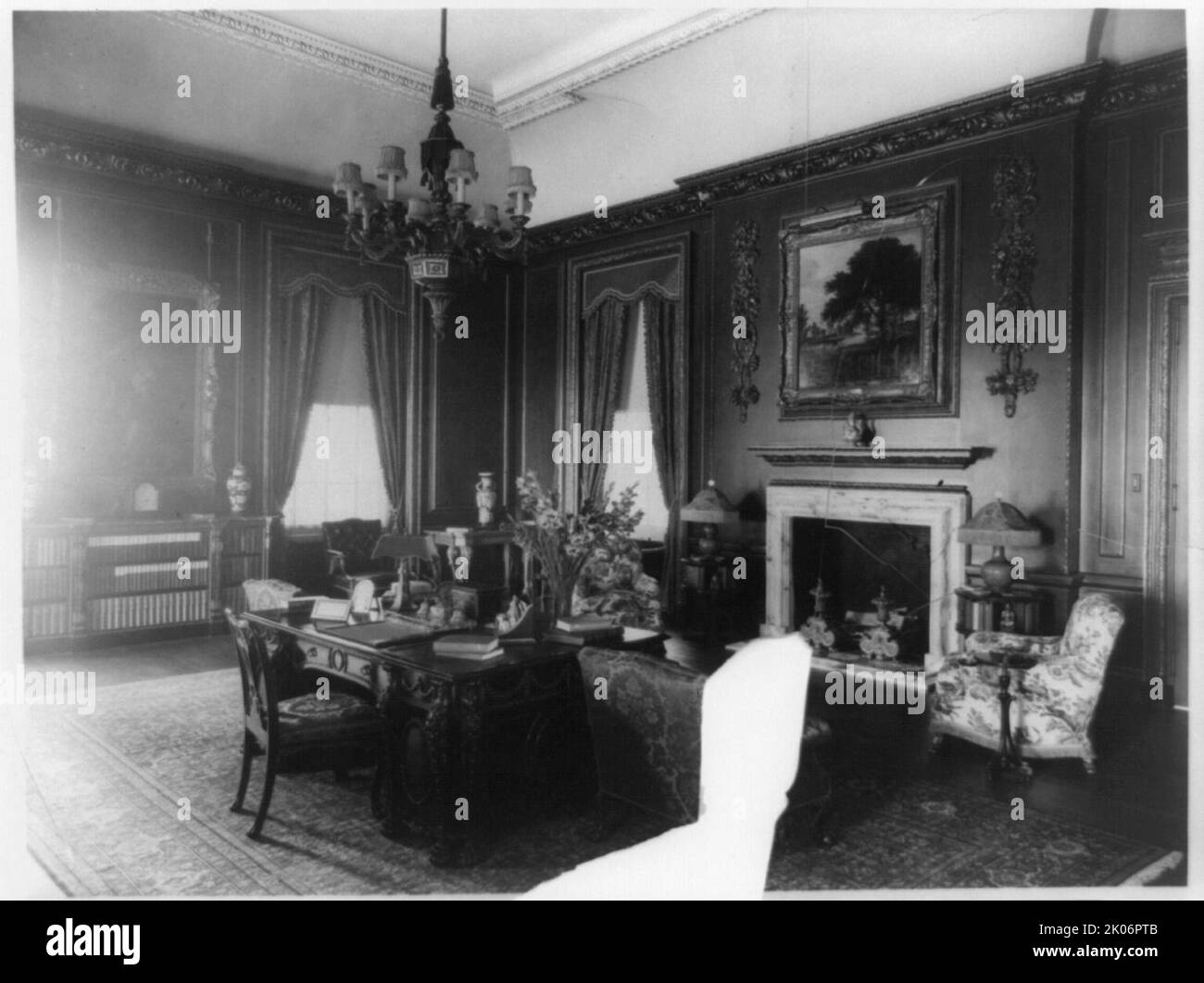 Interior view of Mrs. Hamilton Rice home in Newport, Rhode Island, with desk and fireplace, between 1917 and 1927. The Miramar neoclassical mansion was designed by Horace Trumbauer for heiress and philanthropist Eleanor Elkins Widener and her husband George Widener. After George died aboard the RMS Titanic in 1912 Eleanor married again, and Miramar was used as a summer residence by her and her second husband, geographer and explorer Alexander H. Rice Jr. Stock Photo