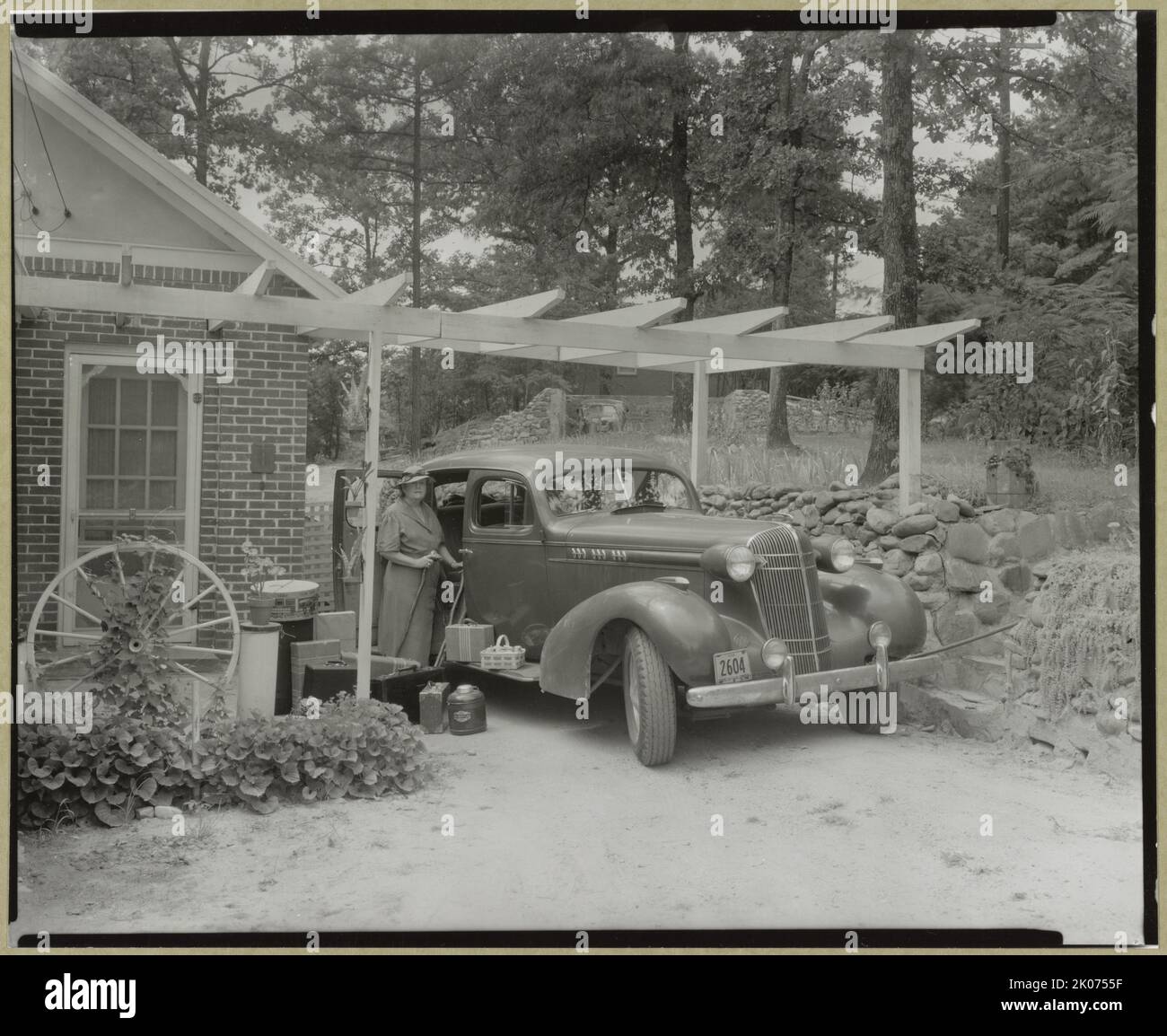 Frances B. Johnston at the Wheel Inn, Morganton, N.C., 1938. The photographer Frances B. Johnston standing with her luggage by the car she rode in to document historic buildings for the Carnegie Survey of the Architecture of the South. Stock Photo