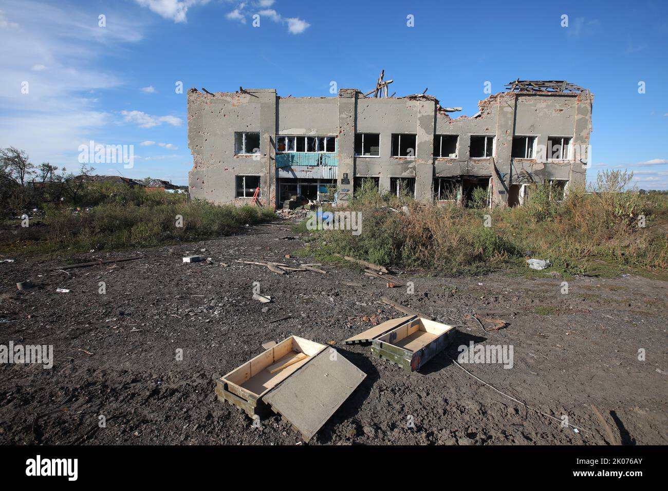 HRAKOVE, UKRAINE - SEPTEMBER 9, 2022 - Empty ammunition boxes lie on the ground outside a destroyed village council building in Hrakove village which Stock Photo