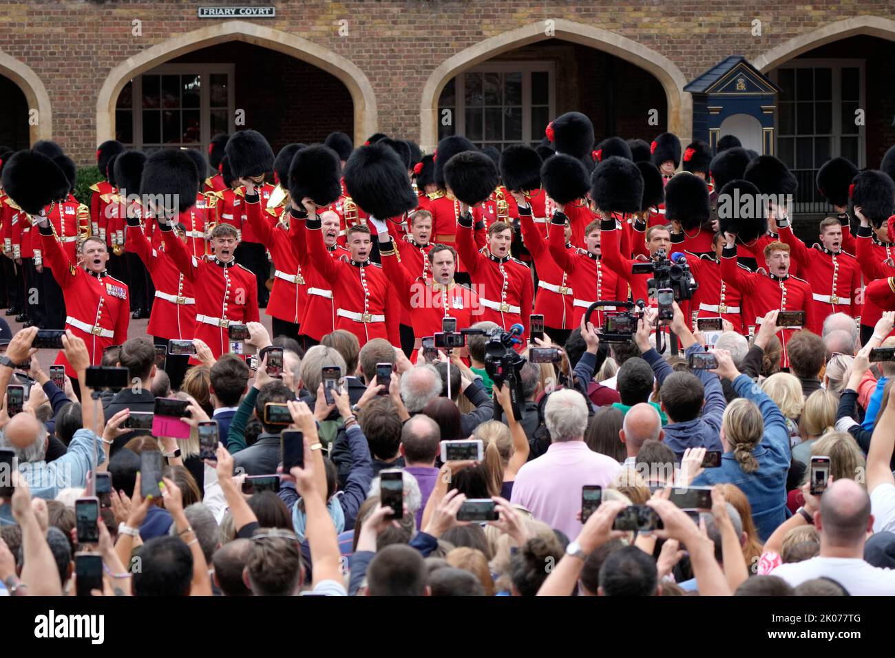 The public look on as members of the Coldstream guards cheer as the Principal Proclamation is read from the balcony overlooking Friary Court after the Accession Council ceremony at St James's Palace, London, where King Charles III was formally proclaimed monarch. Charles automatically became King on the death of his mother, but the Accession Council, attended by Privy Councillors, confirms his role. Picture date: Saturday September 10, 2022. Stock Photo
