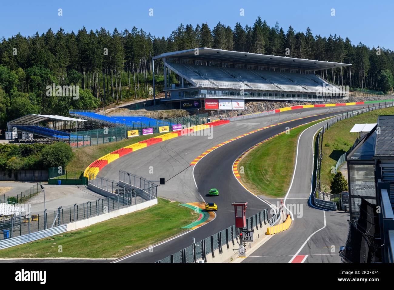 View of two Porsche GT3 racing cars racing through dangerous Eau Rouge bend onto 40-metre-high Raidillon slip road of Circuit de Spa Francorchamps Stock Photo