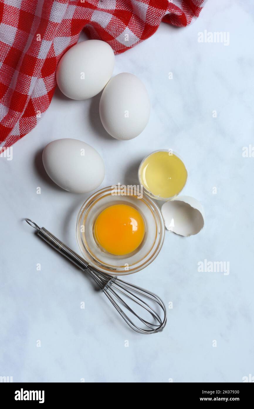 Egg yolk in small bowl and egg white in egg shell Stock Photo Alamy
