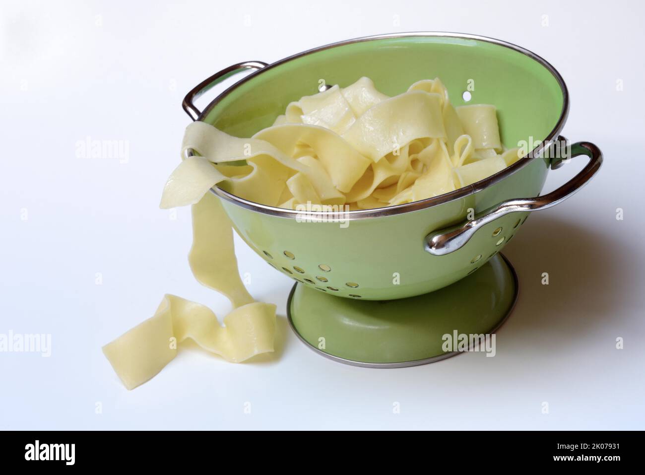 Pappardelle, cooked, wide Italian ribbon noodles in kitchen sieve