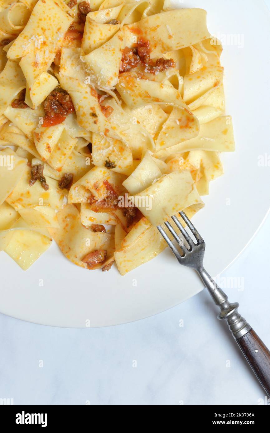Pappardelle, cooked, wide Italian ribbon noodles with Bolognese sauce