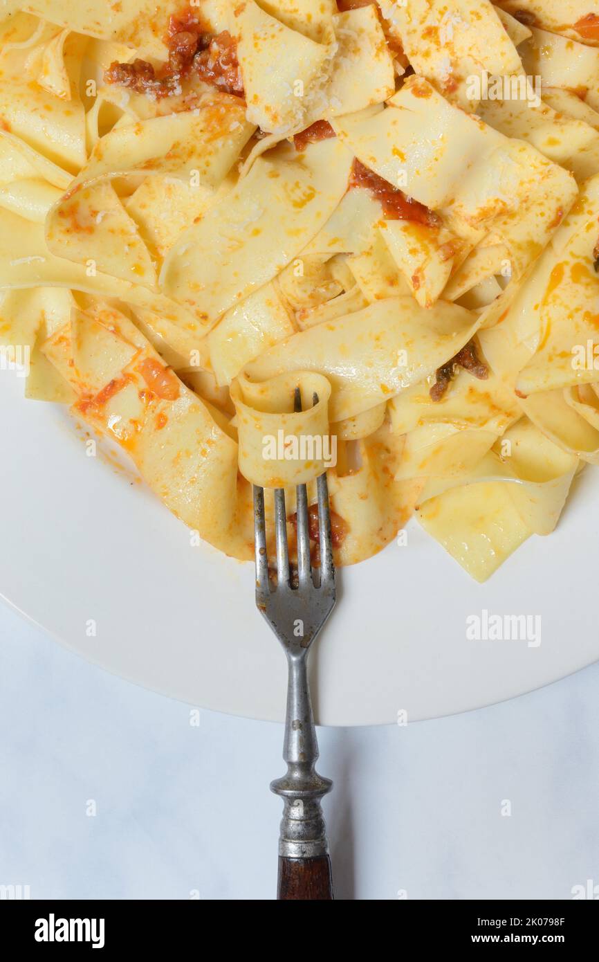 Pappardelle, cooked, wide Italian ribbon noodles with Bolognese sauce