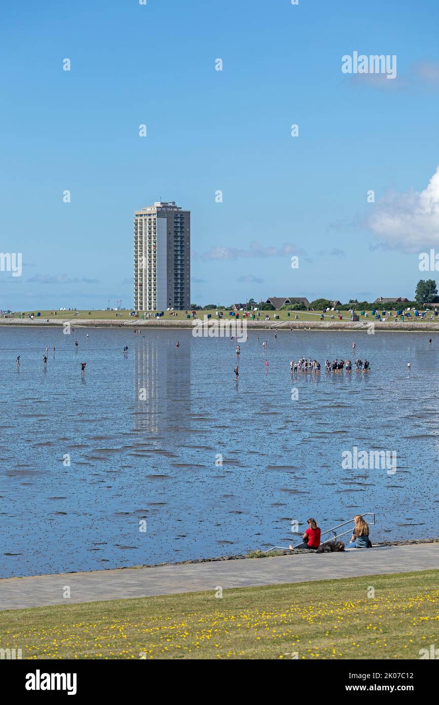 people on the intertidal mudflats, high-rise building, Büsum, Schleswig-Holstein, Germany Stock Photo