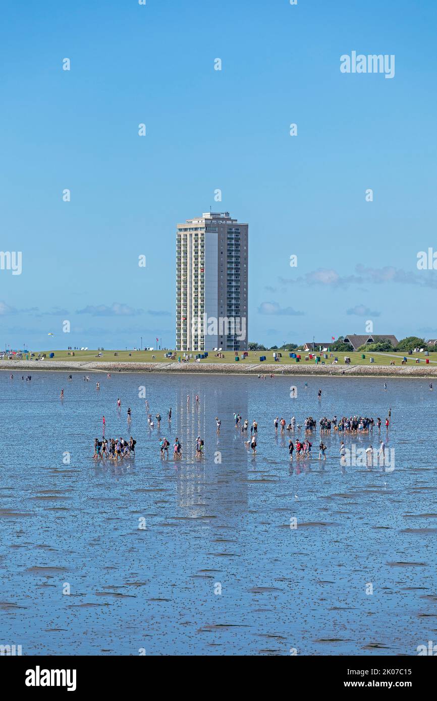 people on the intertidal mudflats, high-rise building, Büsum, Schleswig-Holstein, Germany Stock Photo