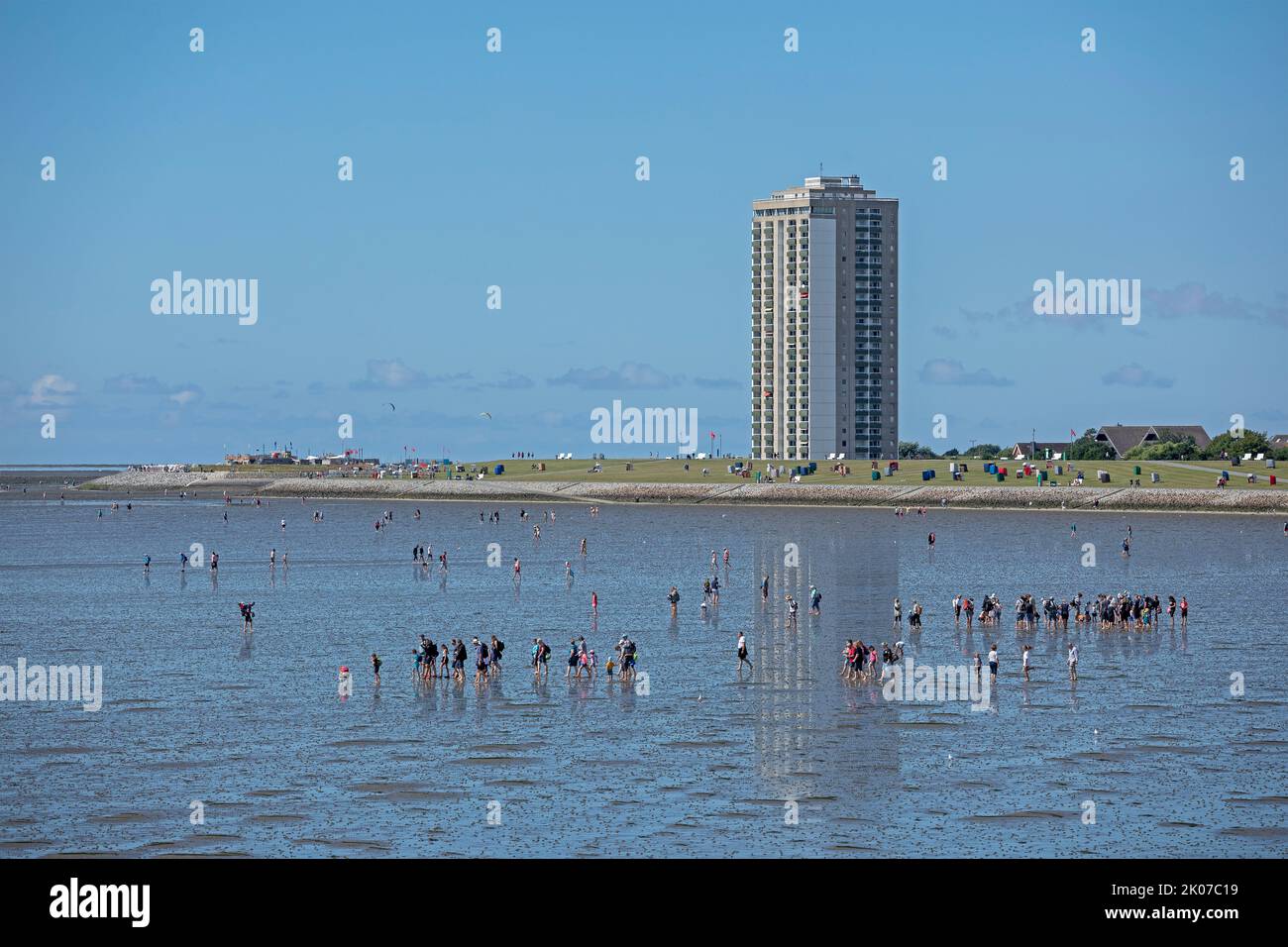 people on the intertidal mudflats, high-rise building, Büsum, Schleswig-Holstein, Germany Stock Photo