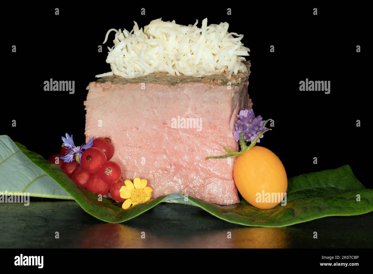 Pink roast beef with freshly grated horseradish, yellow cherry tomato