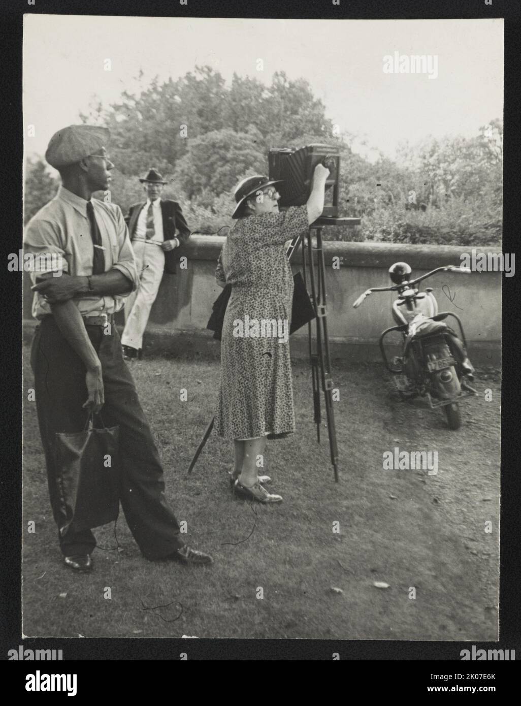Photographer Frances Benjamin Johnston standing beside her view camera ...