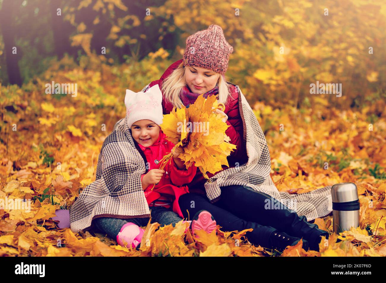 Mother and child hands in the autumn park in the middle of the orange ...