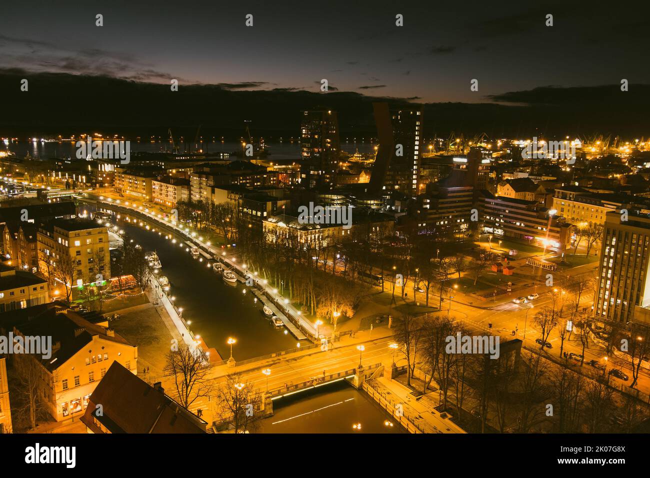 Aerial view of beautiful cityscape of Klaipeda at night. Yachts and boats docked along the