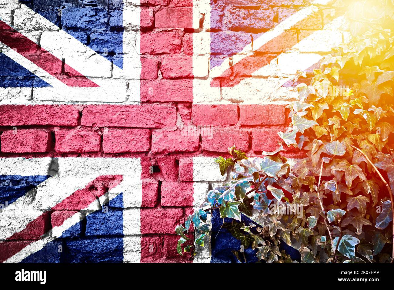 UK grunge flag on brick wall with ivy plant sun haze view, country symbol concept Stock Photo