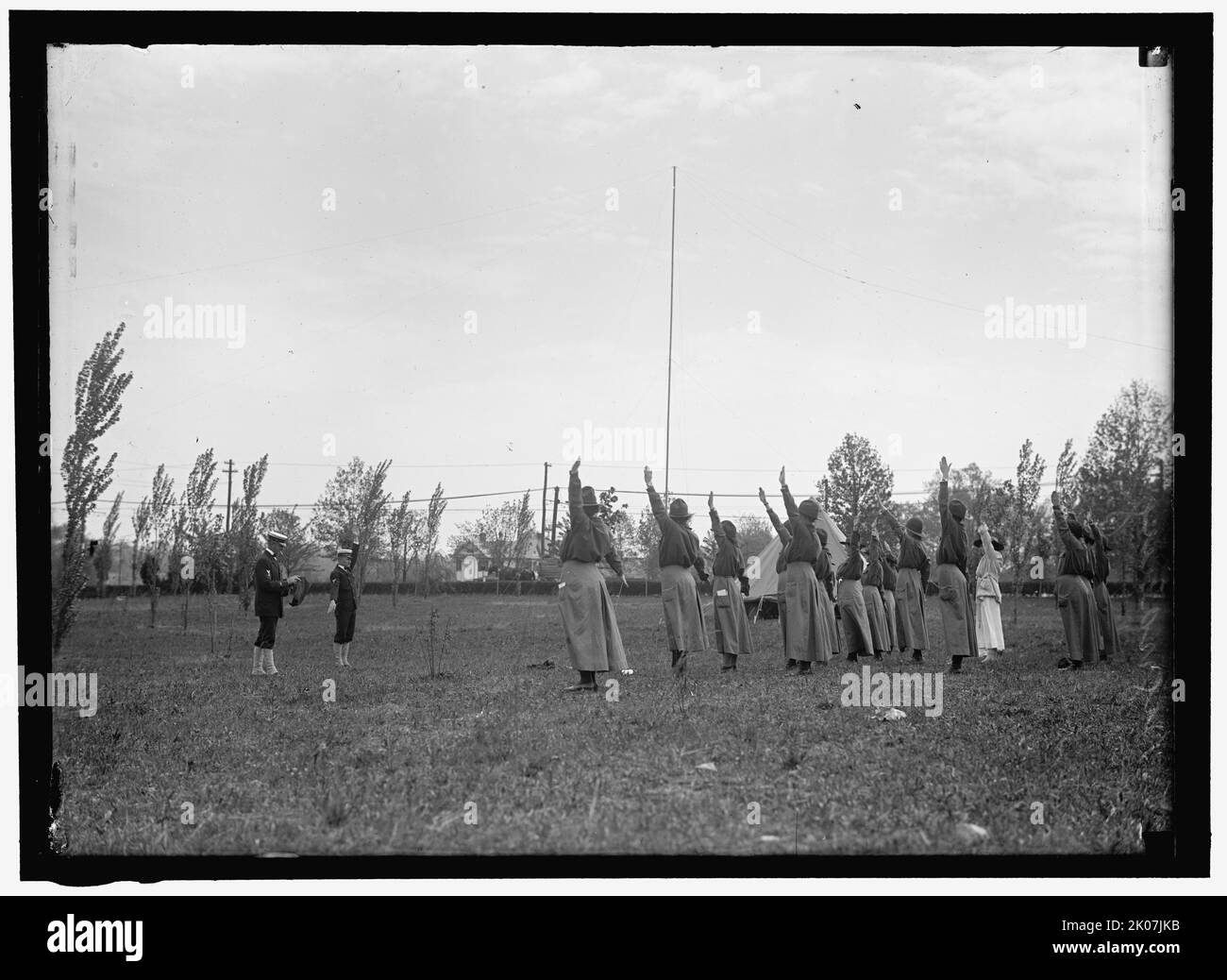 Signaling, between 1910 and 1917. USA. Man in military uniform teaching women (scout leaders?) semaphore. Stock Photo
