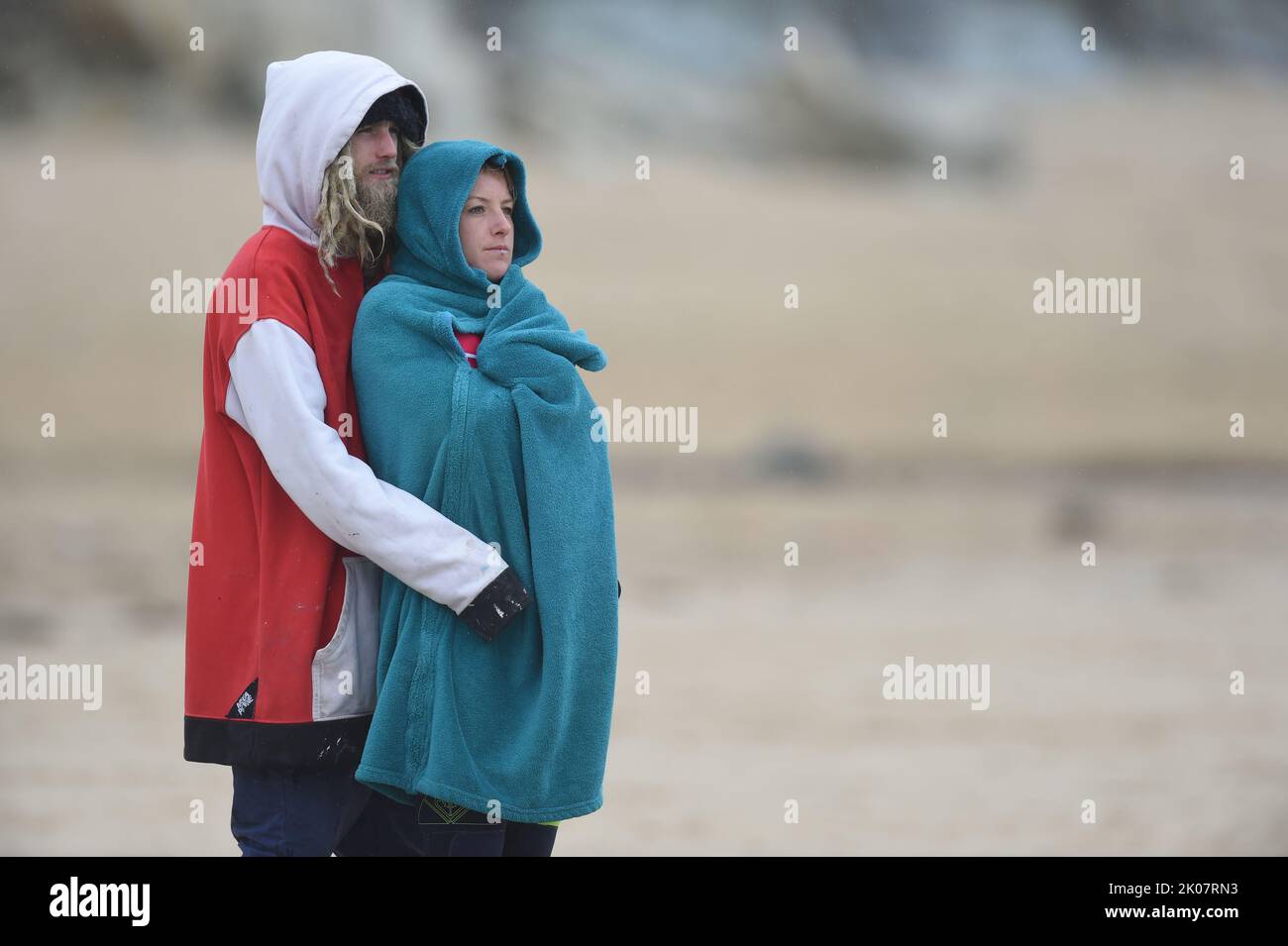 Young couple male and female wrapped in blanket and warm clothing