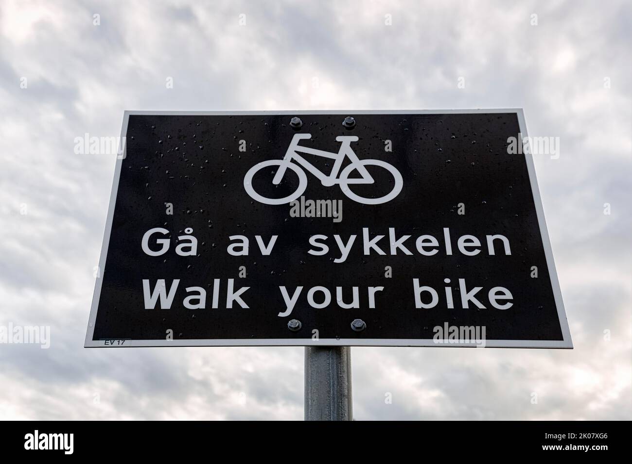 Black and white traffic sign, bilingual with pictogram bicycle and inscription Push your bike, cyclists dismount, Norway Stock Photo