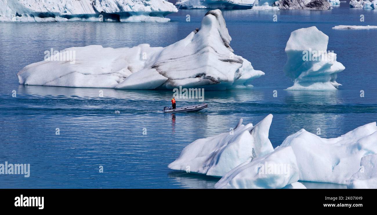 Rubber dinghy in front of icebergs in Joekulsarlon glacier lagoon, Vatnajoekull National Park, Hornarfjoerdur, Iceland Stock Photo