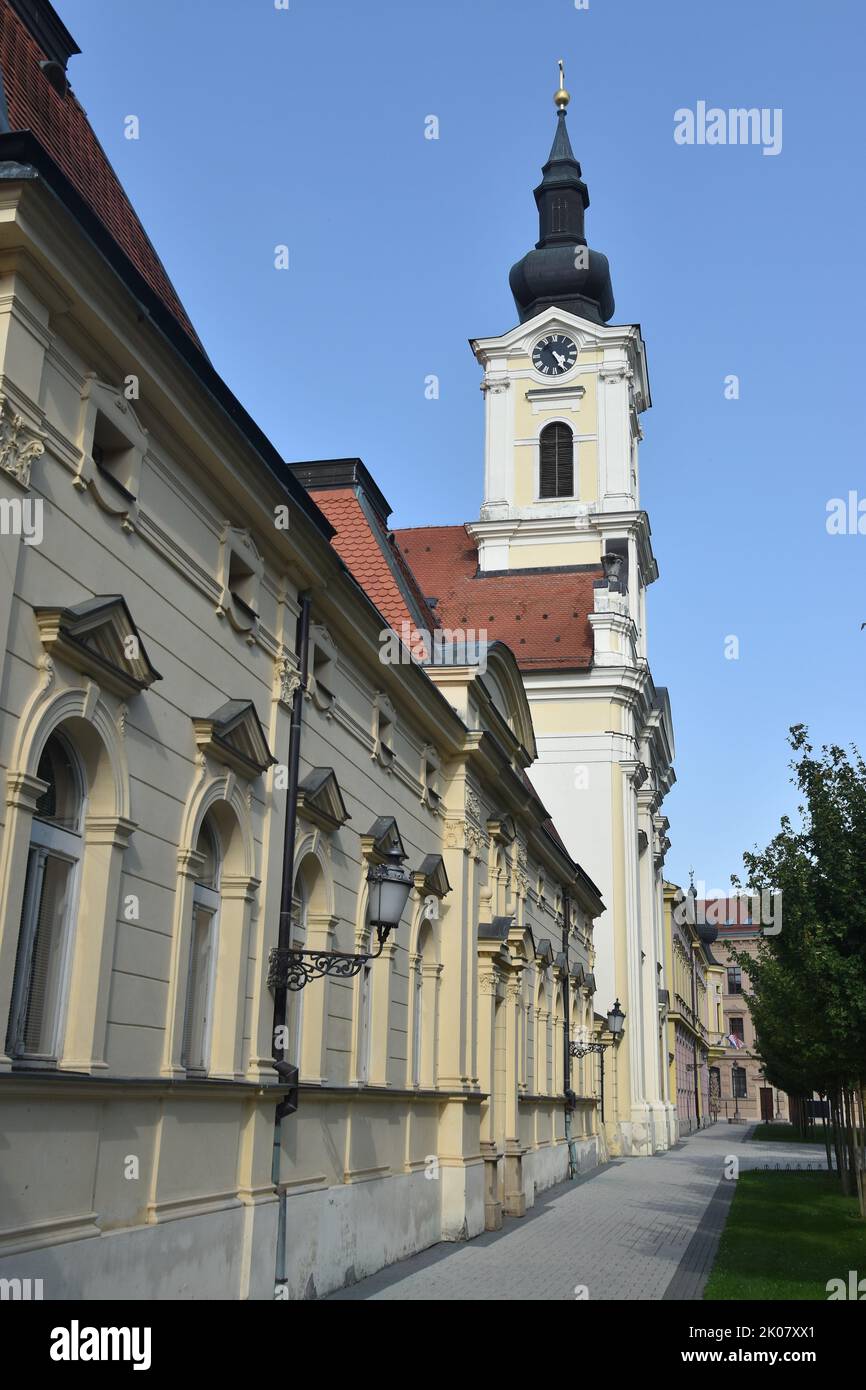 the baroque town of Vinkovci in Eastern Croatia, Slavonia: the Catholic church and the parish house Stock Photo