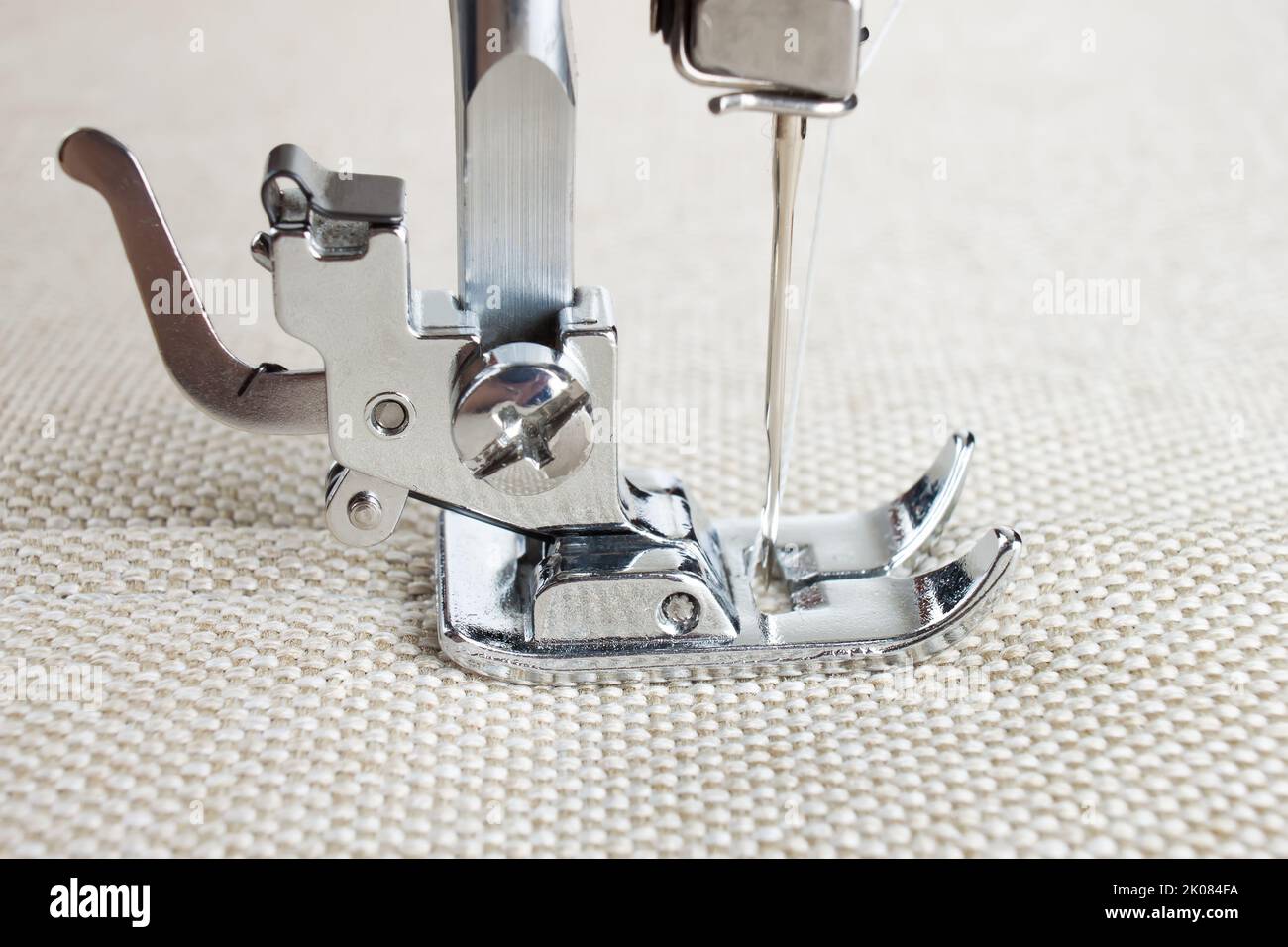 Modern sewing machine presser foot makes a seam on fabric. sewing