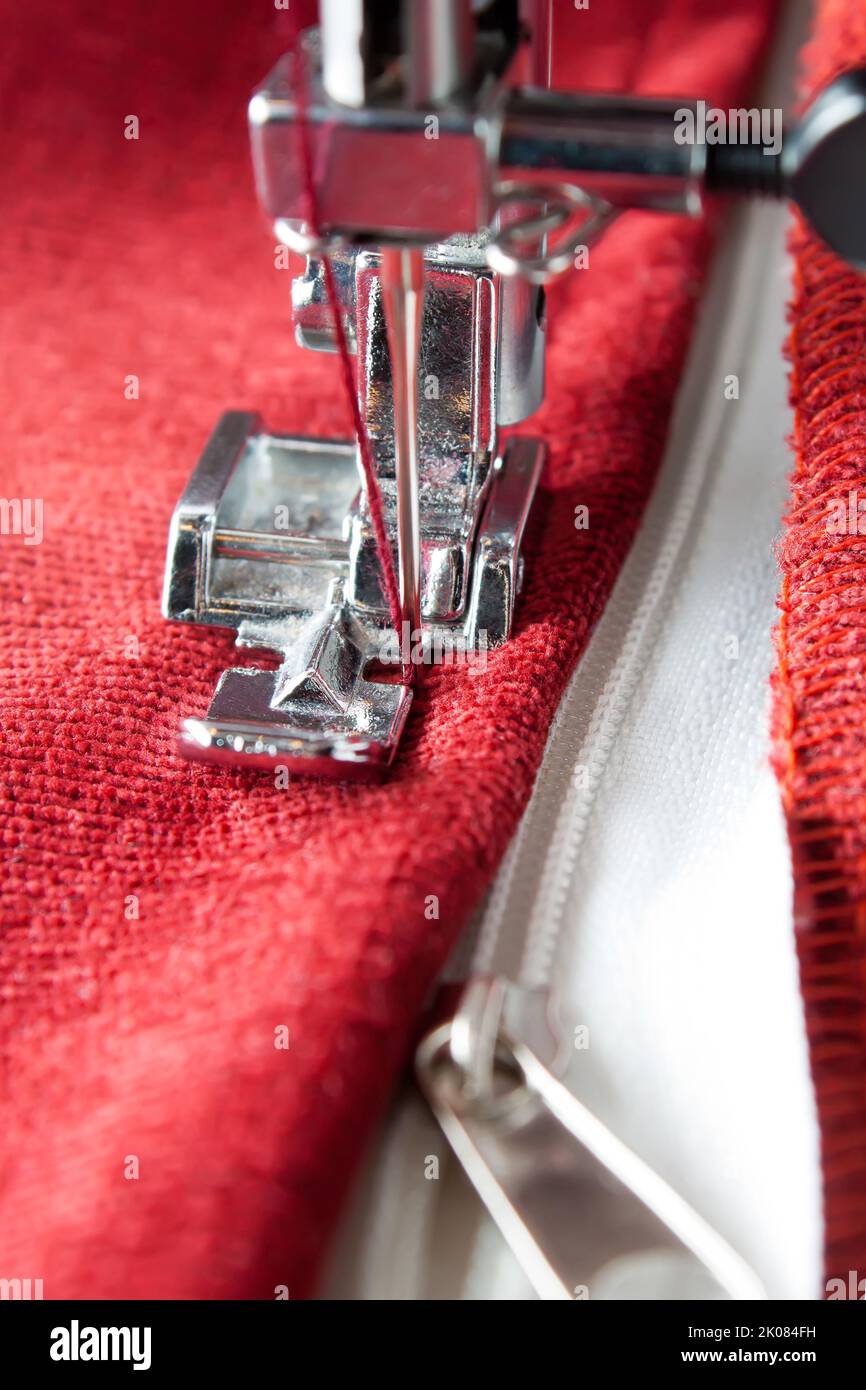 Modern sewing machine with special presser foot sews on the zipper on