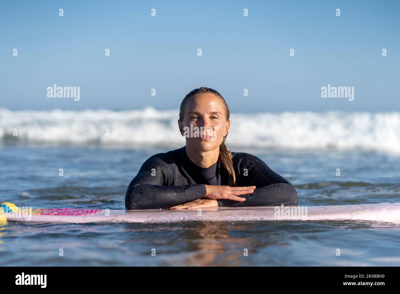 Surfer girl with her surfboard in the water. Female surfer woman Stock Photo