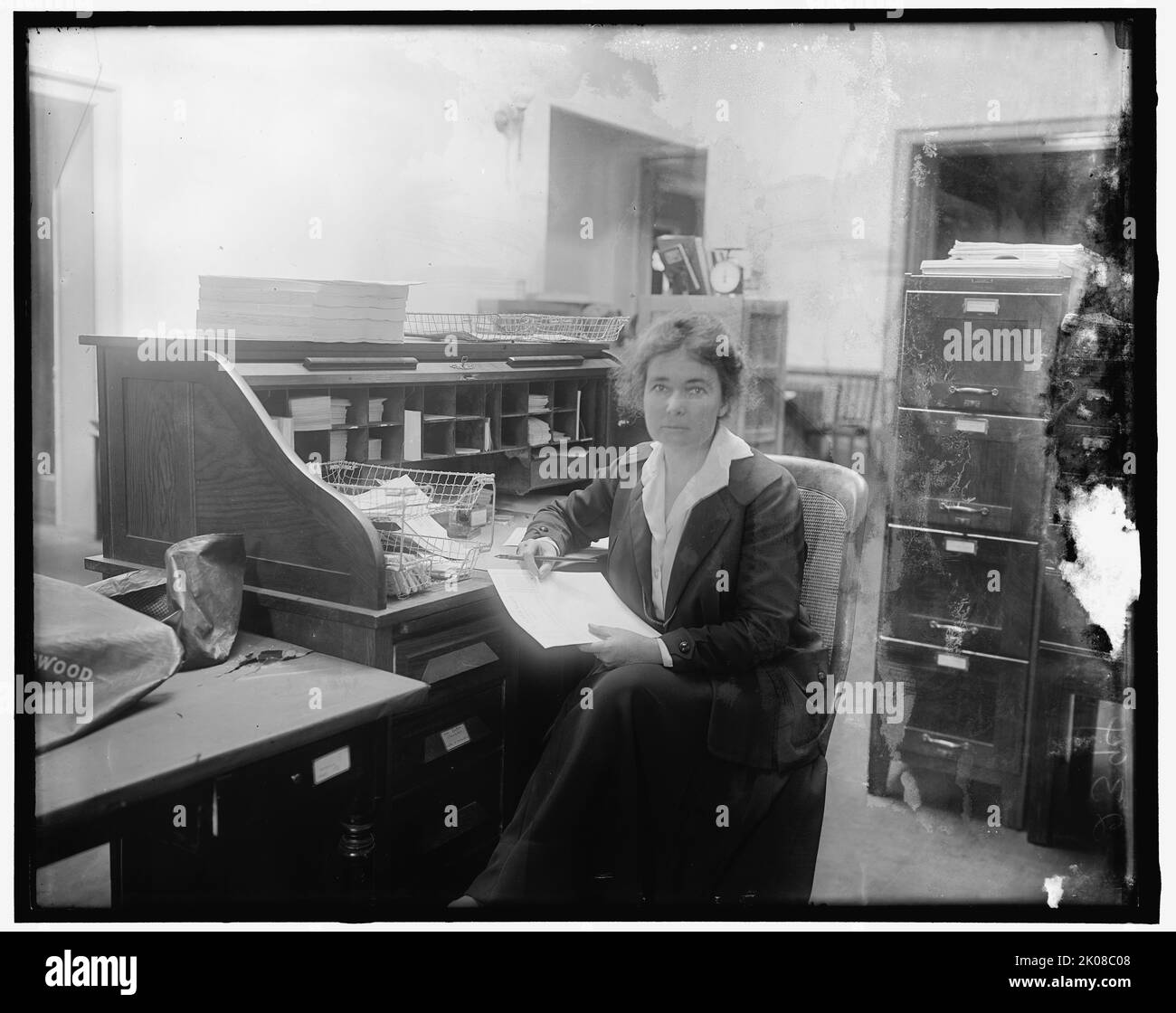Anne Martin, between 1910 and 1920. American activist, suffragist, pacifist, and author Anne Henrietta Martin in her office, holding a copy of 'The Suffragist'. Martin was president of the Nevada Equal Franchise Society; speaker and executive committee member of the National American Woman Suffrage Association and the Congressional Union; instrumental in obtaining for the women of Nevada the right to vote; active in the suffrage movement in England, working with Emmeline Pankhurst; first national chairman of the National Woman's Party; first woman to run for the United States Senate. Stock Photo
