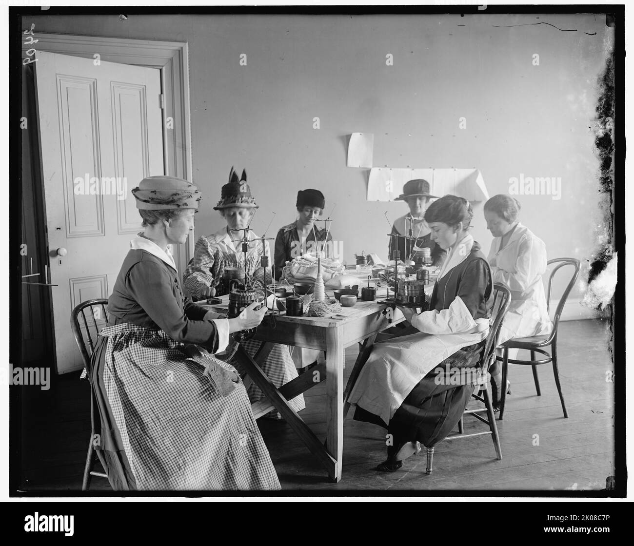 Comforts Committee of Navy League, between 1910 and 1920. USA. First World War: women using circular knitting machines to produce socks for sailors. The Navy League of the United States, founded in 1902, describes itself as &quot;a civilian organization dedicated to the education of our citizens, including our elected officials, and the support of the men and women of the sea services and their families&quot;. Stock Photo