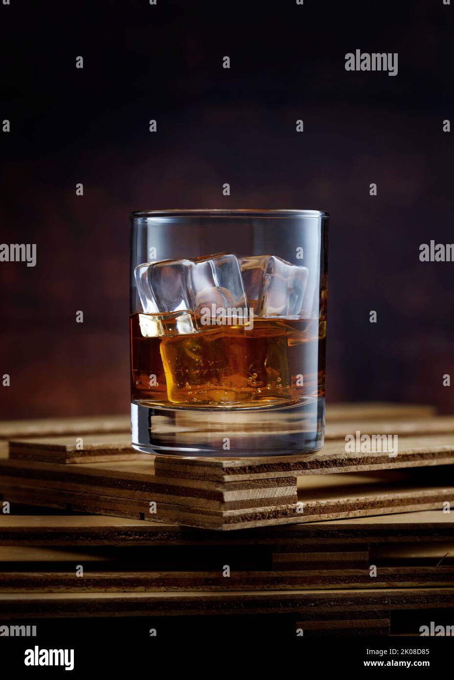 Premium Photo  Whiskey or bourbon in a rocks glass with a big ice cube  shot with hard light and harsh shadows bright backdrop copy space