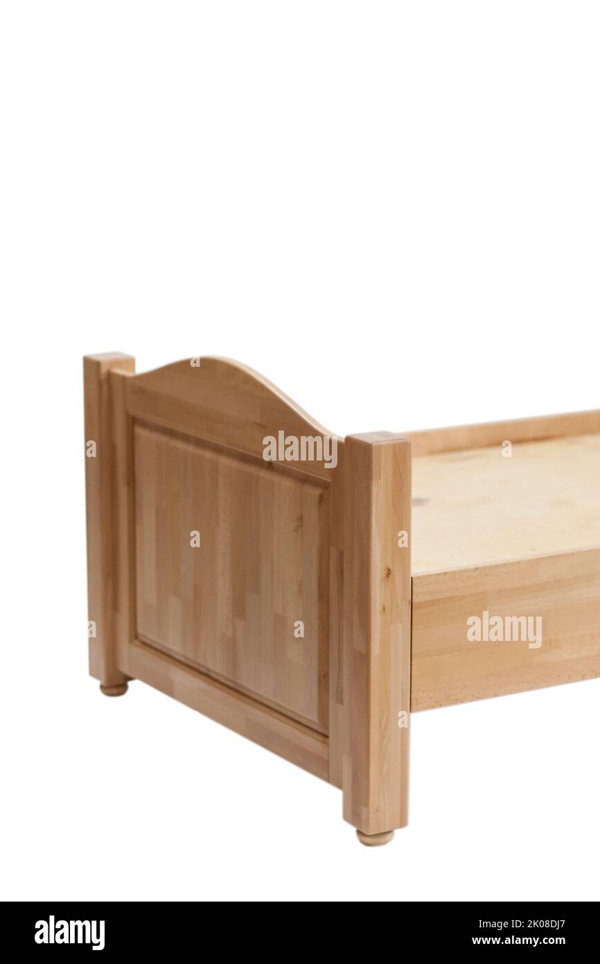 Close-up of a part of a wooden bed for sleeping. Classic sleeping bed furniture made of natural wood. Stock Photo