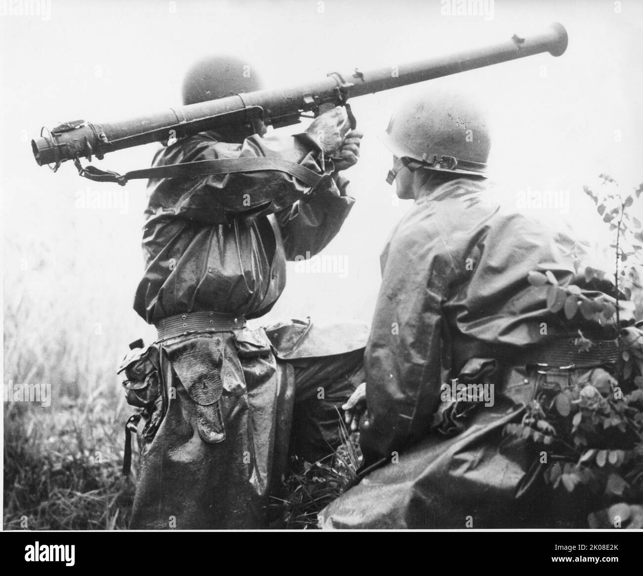 An American soldier, Robert L. Witzig, with a 2.36-inch bazooka prepares to take aim at a North Korean tank during the Battle of Pyongtaek which took place after the Battle of Osan. On his right is Kenneth R. Shadrick, who was later reported as the first American killed in the Korean War. 5 July 1950 Stock Photo