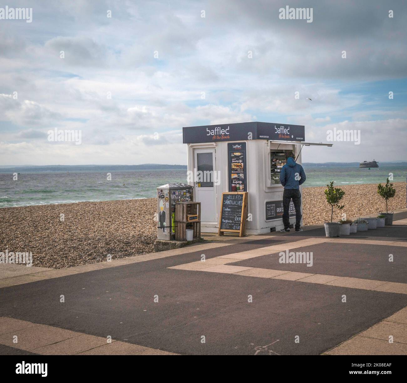 Seaside beach kiosk with customer at the hatch. Stock Photo