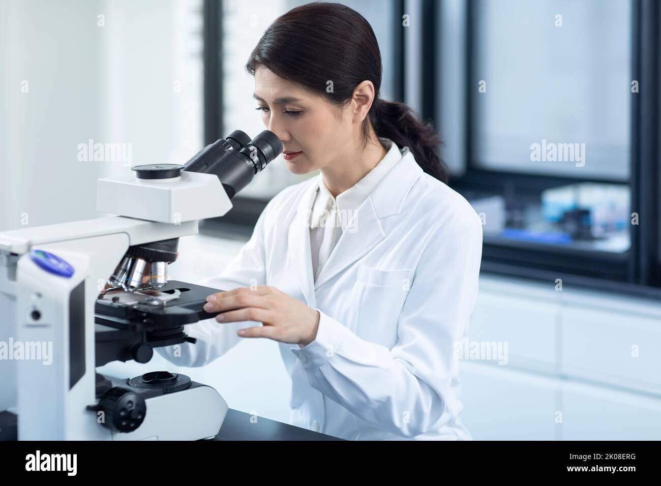 Chinese scientist looking through a microscope Stock Photo Alamy