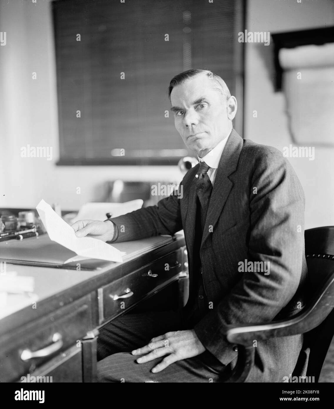 S.G. Hopkins, between 1910 and 1920. Man at writing desk reading letter. Stock Photo