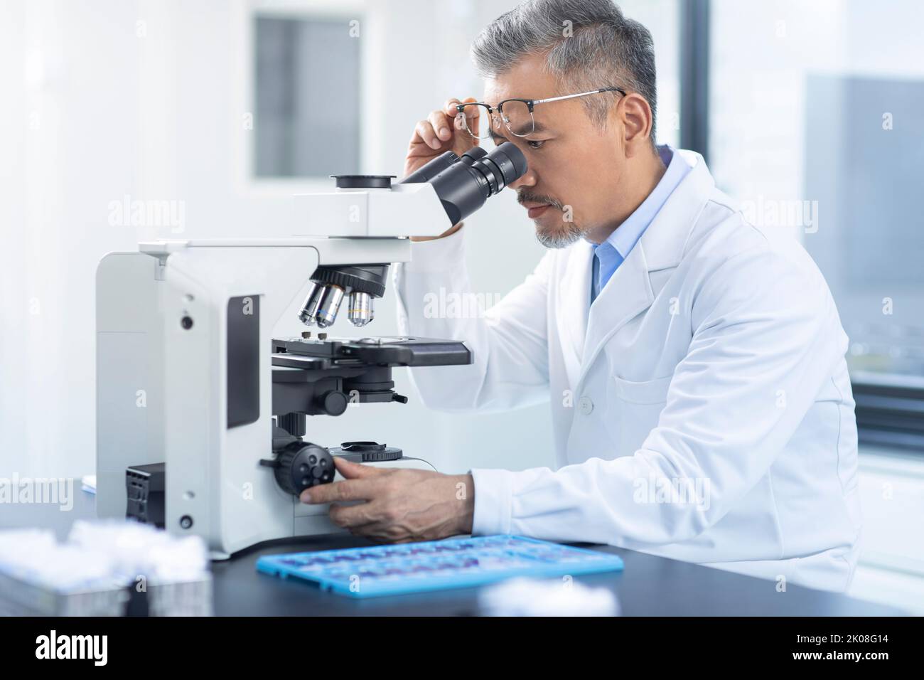 Chinese scientist looking through a microscope Stock Photo Alamy