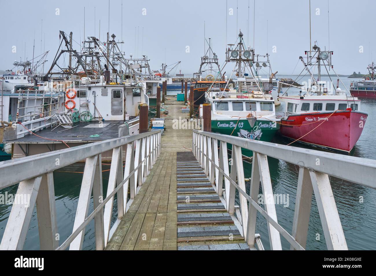 Ramp leading down to the dock in Forchu Nova Scotia where numerous fishing boats are tied up. Stock Photo