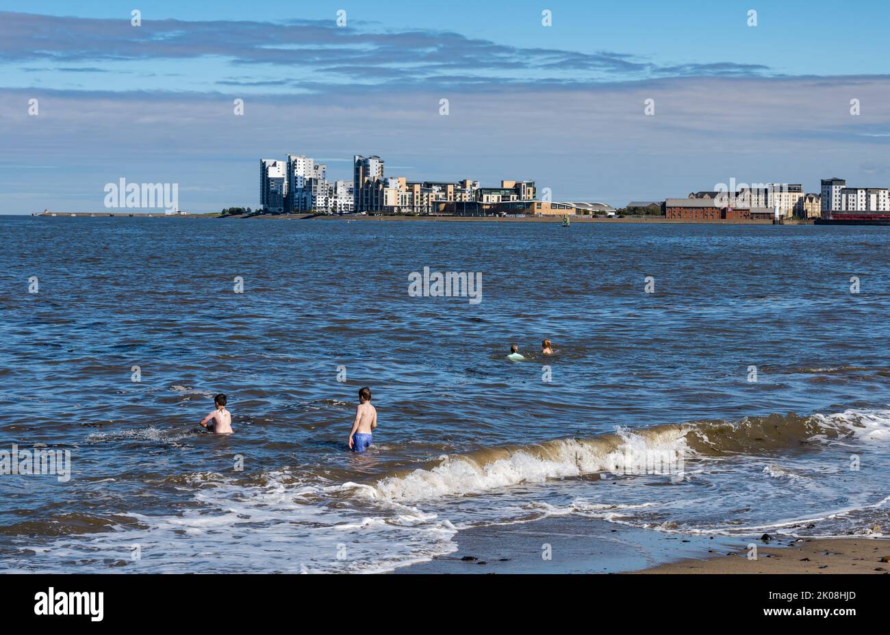 Leith, Edinburgh, Scotland, UK, 10th September 2022. UK Weather: sunshine on Granton. A very warm September day for people to swim in the sea at the small beach at Granton harbour in the Firth of Forth with Platinum Point apartment buildings in the distance. Credit: Sally Anderson/Alamy Live News Stock Photo