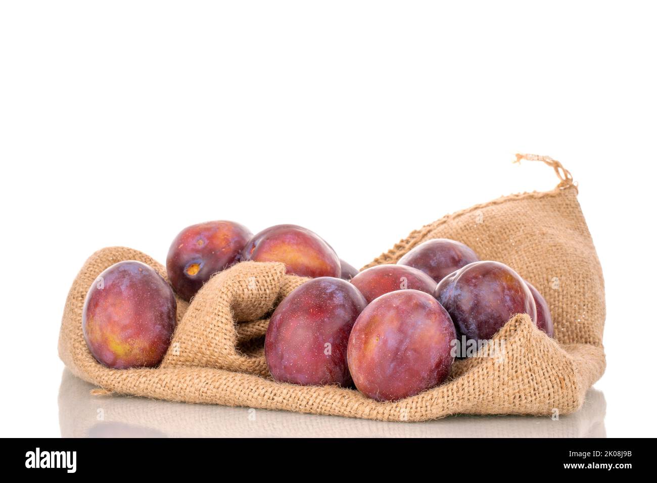 Several juicy plums with a jute bag, macro, isolated on a white background. Stock Photo