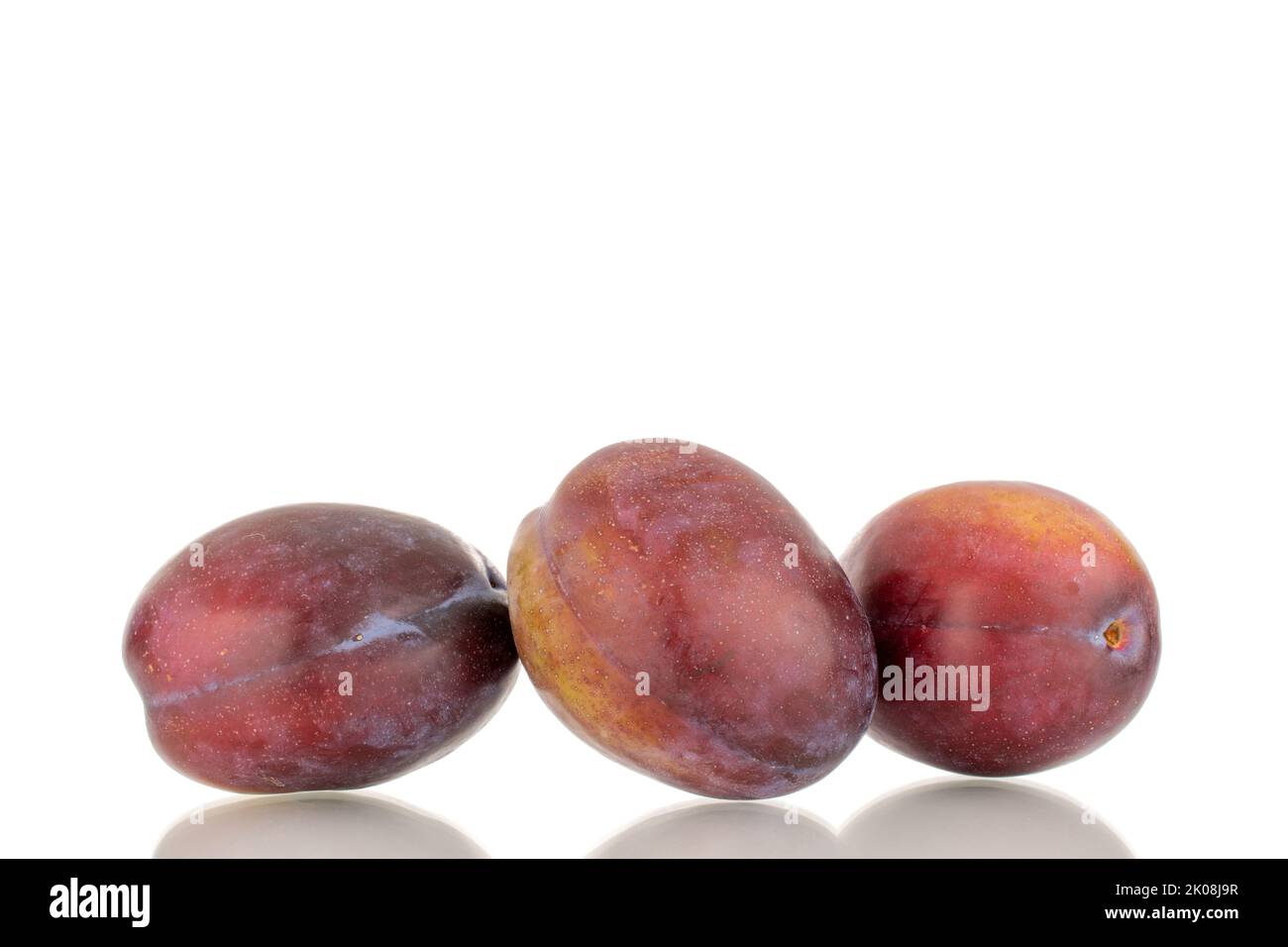 Three ripe plums, macro, isolated on a white background. Stock Photo