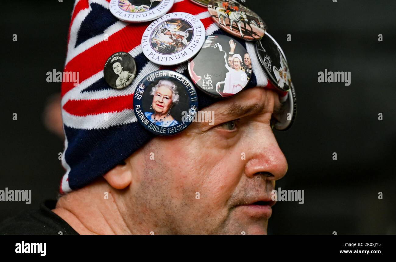 London UK 10th September 2022 - A man wearing Queen Elizabeth badges as Crowds line The Mall in London outside St James's Palace where Charles III was formally proclaimed as king today at 11am : Credit Simon Dack / Alamy Live News Stock Photo