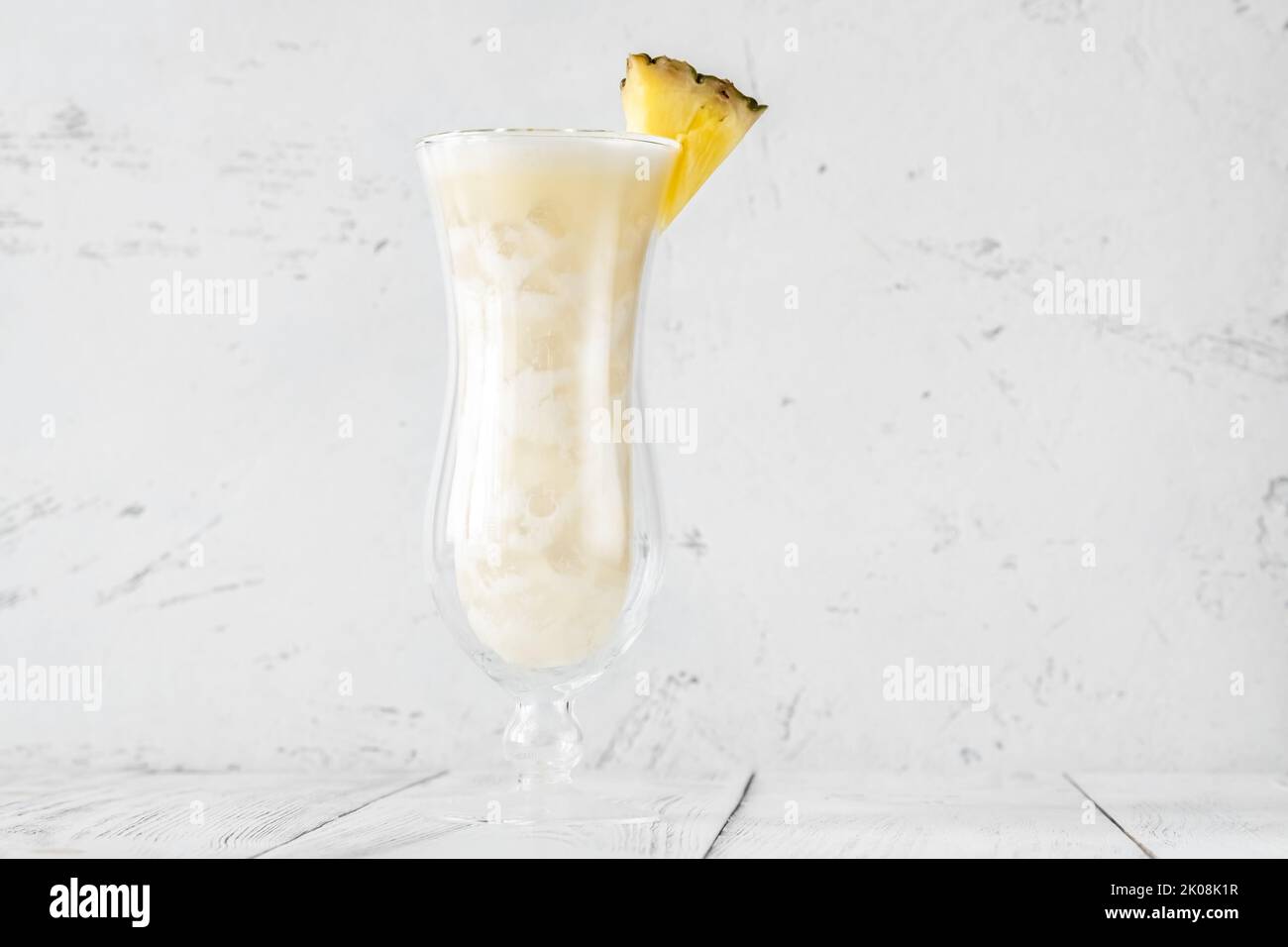Glass of pina colada cocktail garnished with pineapple wedge Stock Photo