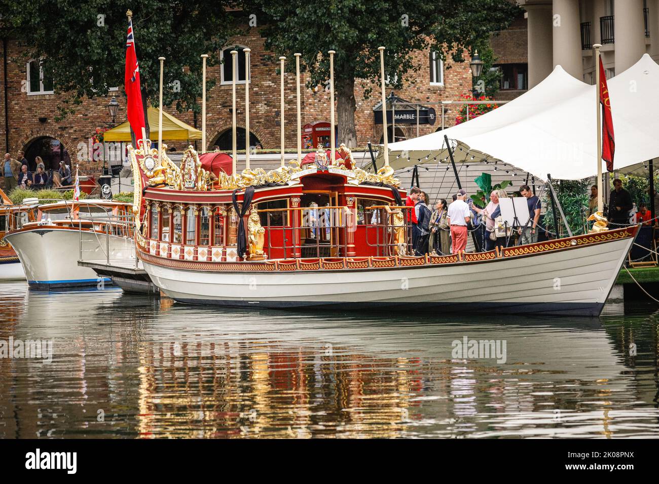 London, UK, 10th Sep 2022. The Gloriana in her 'mourning dress', with black cloth ribbons wrapped around the ornamental golden lions. Gloriana, the Queen's Rowbarge, is this weekend moored in St Katherine Docks for the boat festival. The Royal Rowbarge was built as a tribute to and lasting legacy for Queen Elizabeth's Diamond Jubilee in 2012, named 'Gloriana' by Her Majesty, and led the Thames Diamond Jubilee Pageant, as well as other occasions since then. The barge may play a role in next week's proceedings around the funeral procession, but this is as yet unconfirmed. Credit: Imageplotter Stock Photo