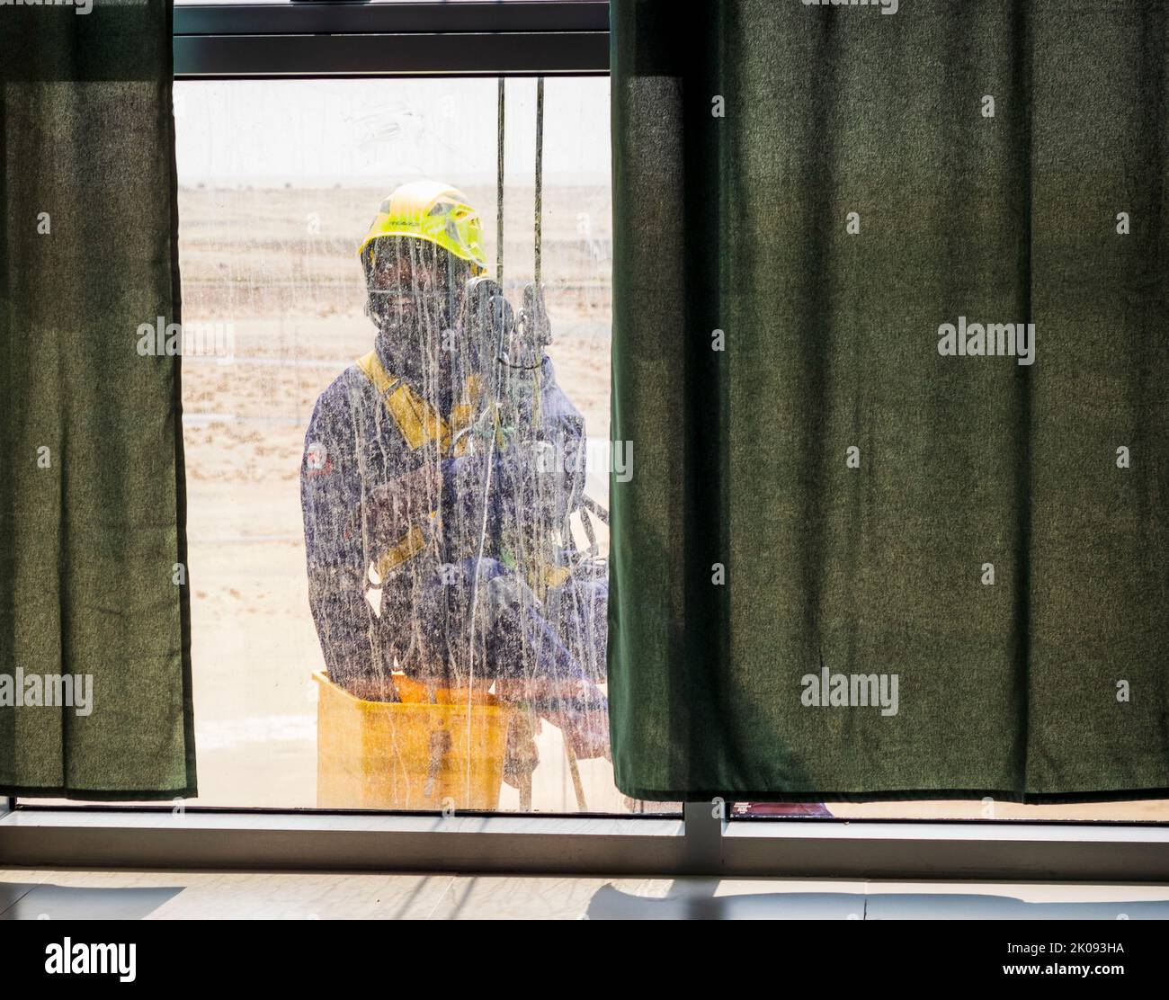 Silhouette of a rope access glass cleaner working at heights Stock